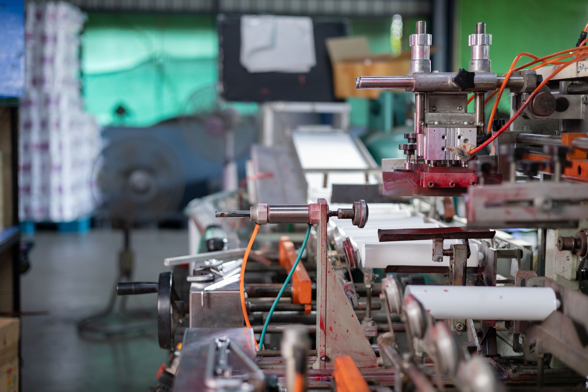 Factory workers inspect plastic bottle skin machines with tools
